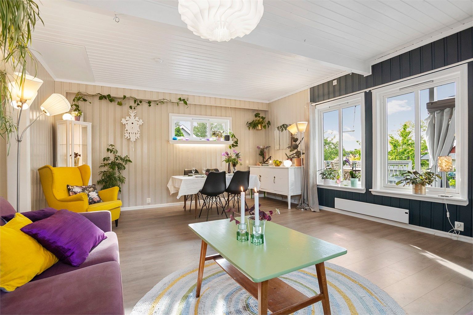 Lys stue med god plass til sofagruppe, spisestue og tilhørende møblement 