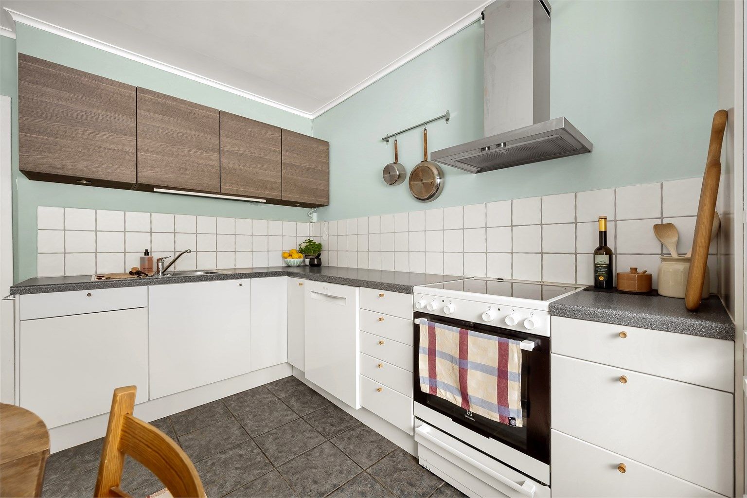 Kjøkkenet er utstyrt med frittstående hvitevarer, herunder kjøleskap med frysedel, oppvaskmaskin og komfyr med platetopp, samt veggmontert ventilator.