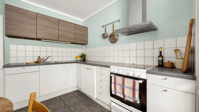 Kjøkkenet er utstyrt med frittstående hvitevarer, herunder kjøleskap med frysedel, oppvaskmaskin og komfyr med platetopp, samt veggmontert ventilator.