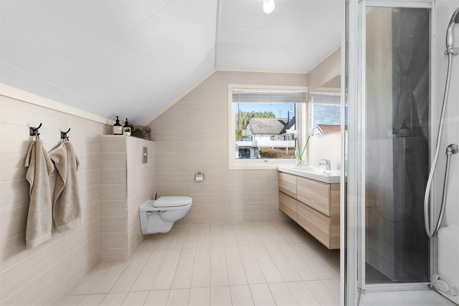 Romslig bad i loftsetasjen, overflateoppusset i ca. 2012. Rommet har gulvvarme og vegghengt toalett