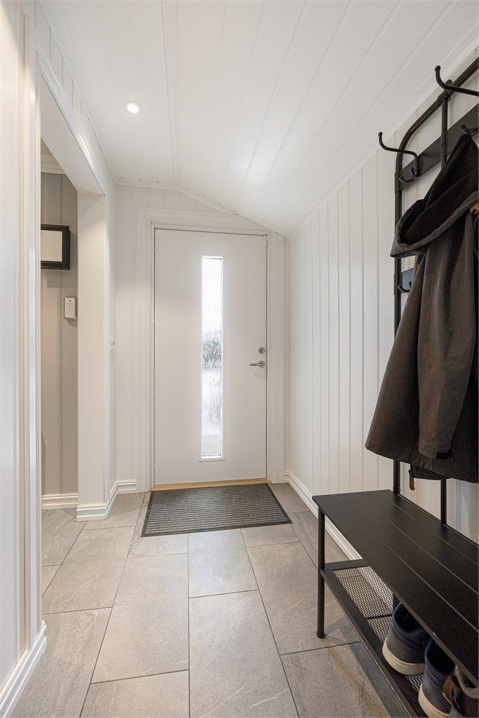 Entréen har flislagt gulv med elektrisk gulvvarme som gir en behagelig velkomst.