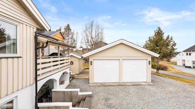 Dobbelgarasje på 46 m² fra 1999, med to leddporter med elektrisk motor.