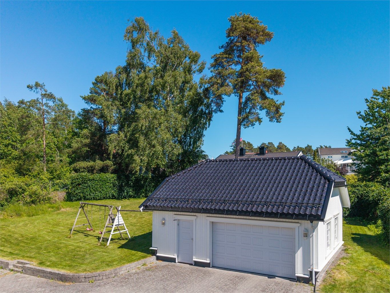 Det er oppført en frittstående dobbeltgarasje med god plass til både biler og utstyr. Fra garasjen fører en innvendig trapp opp til en romslig loftsetasje, som byr på svært gode og praktiske lagringsmuligheter.