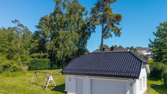 Det er oppført en frittstående dobbeltgarasje med god plass til både biler og utstyr. Fra garasjen fører en innvendig trapp opp til en romslig loftsetasje, som byr på svært gode og praktiske lagringsmuligheter.