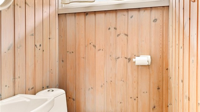 Toalett i eget WC-rom er innredet med klosett og veggmontert servant.