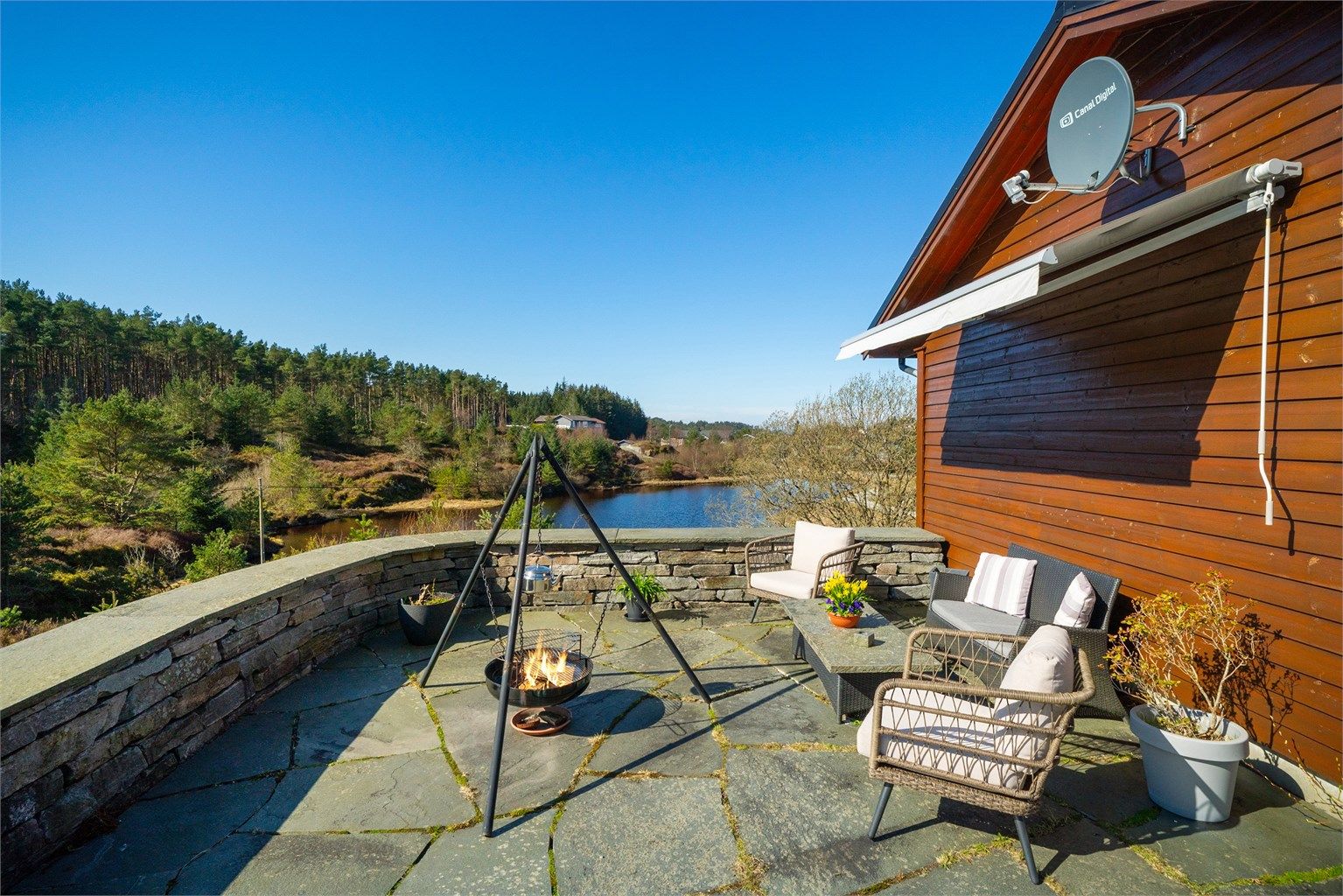 Solrik og hyggelig uteplass belagt med skiferstein hvor man kan nyte fred og ro.