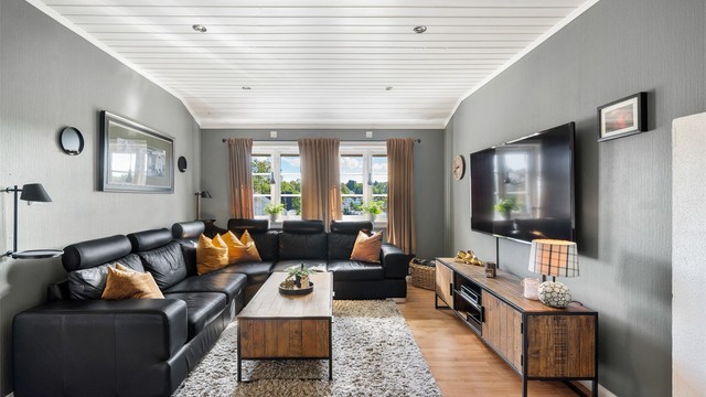 Loftstuen er innredet som en romslig TV-stue med downlights i taket og vinduer mot elva.