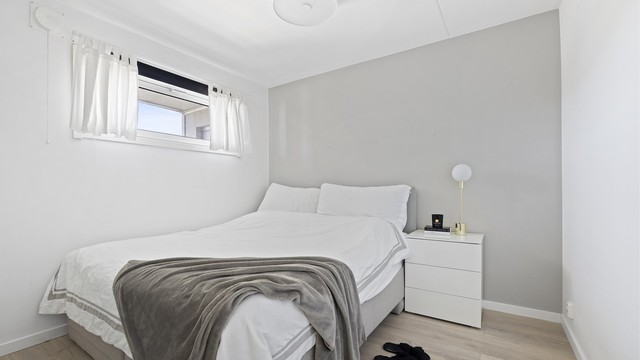 Lunt soverom med plass til blant annet dobbeltseng, nattbord, skrivebord og kontorstol