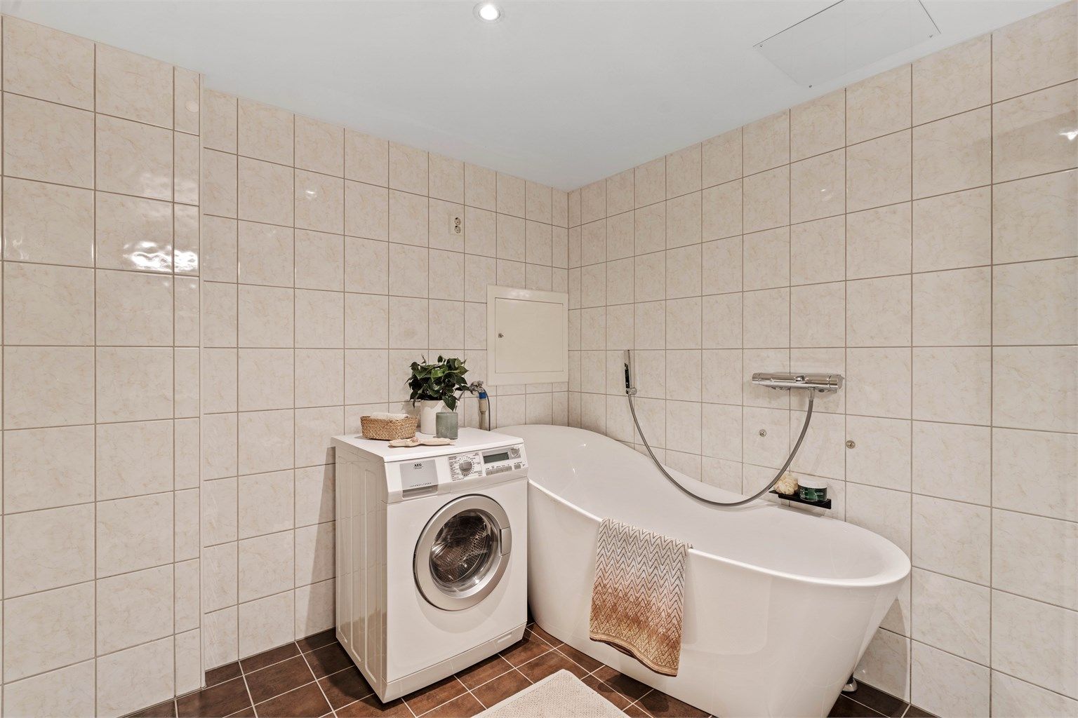 I tillegg til dusj er det badekar og opplegg for vaskemaskin. Kombinert vaskemaskin/tørketrommel medfølger.