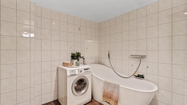 I tillegg til dusj er det badekar og opplegg for vaskemaskin. Kombinert vaskemaskin/tørketrommel medfølger.