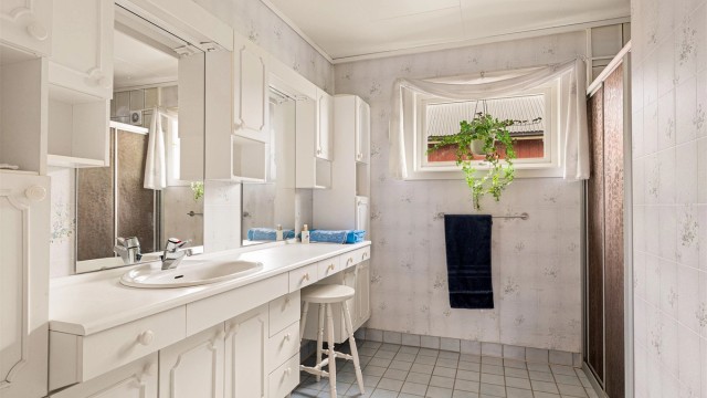 Badet i første etasje har fliser med varmekabler på gulv, baderomsinnredning og dusjhjørne.