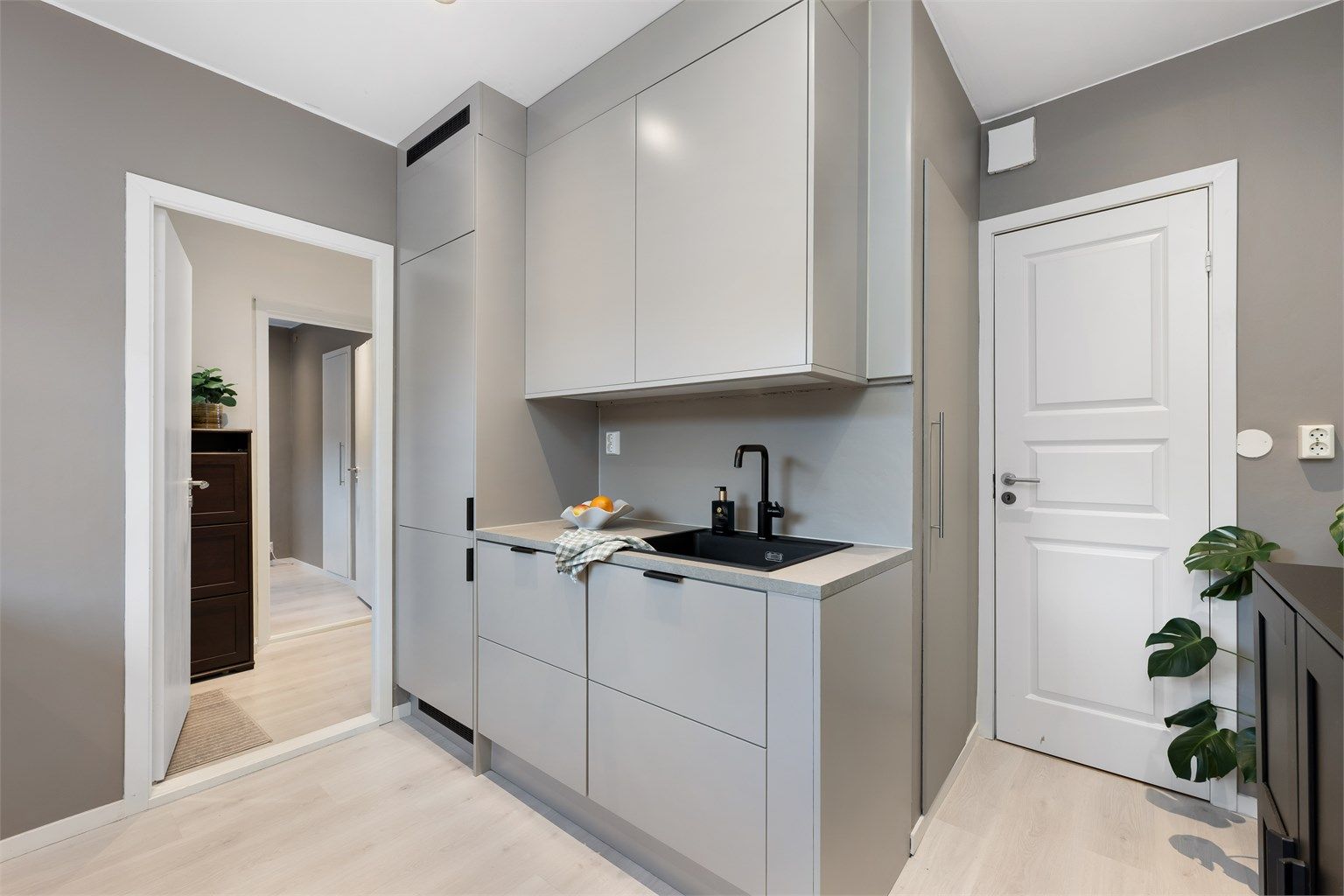 Integrert kjøleskap med fryser i hjørnet. Til høyre er dør til bod. 