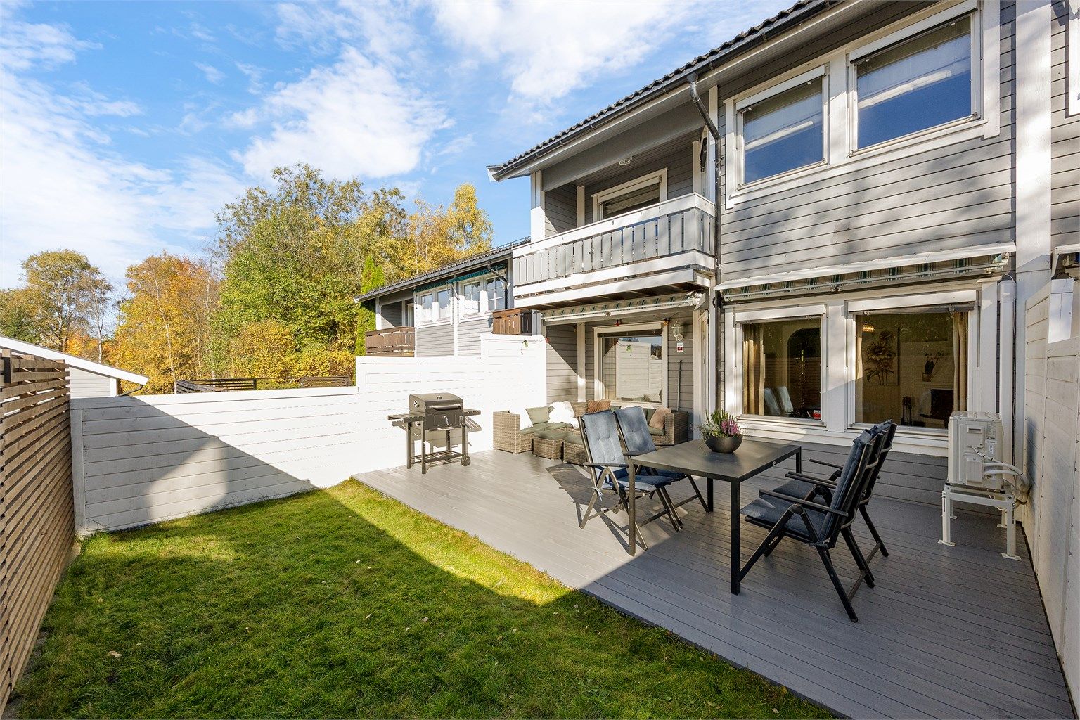 Lettstelt hage med flat gressplen omkranset av treverk