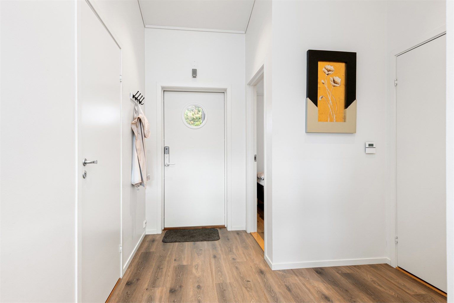 Fra inngangspartiet ønskes du velkommen inn i en innbydende entré. Entréen er utstyrt med elektronisk kodelås og har praktisk adkomst til både bod og leilighetens oppholdsrom.