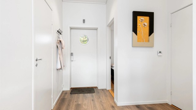 Fra inngangspartiet ønskes du velkommen inn i en innbydende entré. Entréen er utstyrt med elektronisk kodelås og har praktisk adkomst til både bod og leilighetens oppholdsrom.