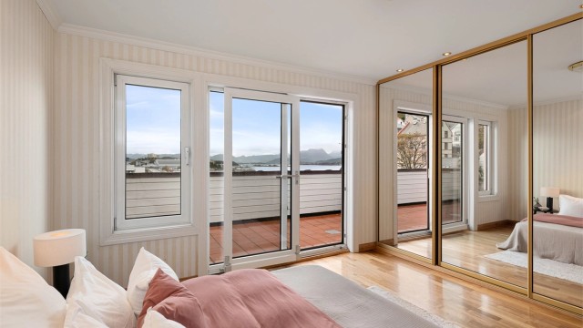 Hovedsoverom med skyvedørsgarderobe med speilfronter og direkte utgang til østvendt balkong.