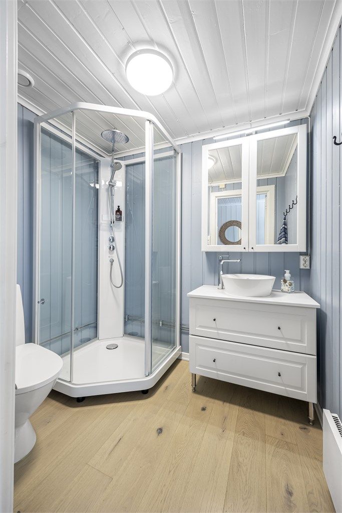 Det andre badet, oppgradert i 2020, er utstyrt med dusjkabinett, gulvstående toalett og servantinnredning.