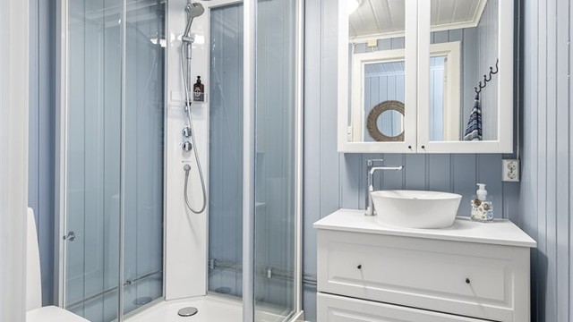 Det andre badet, oppgradert i 2020, er utstyrt med dusjkabinett, gulvstående toalett og servantinnredning.