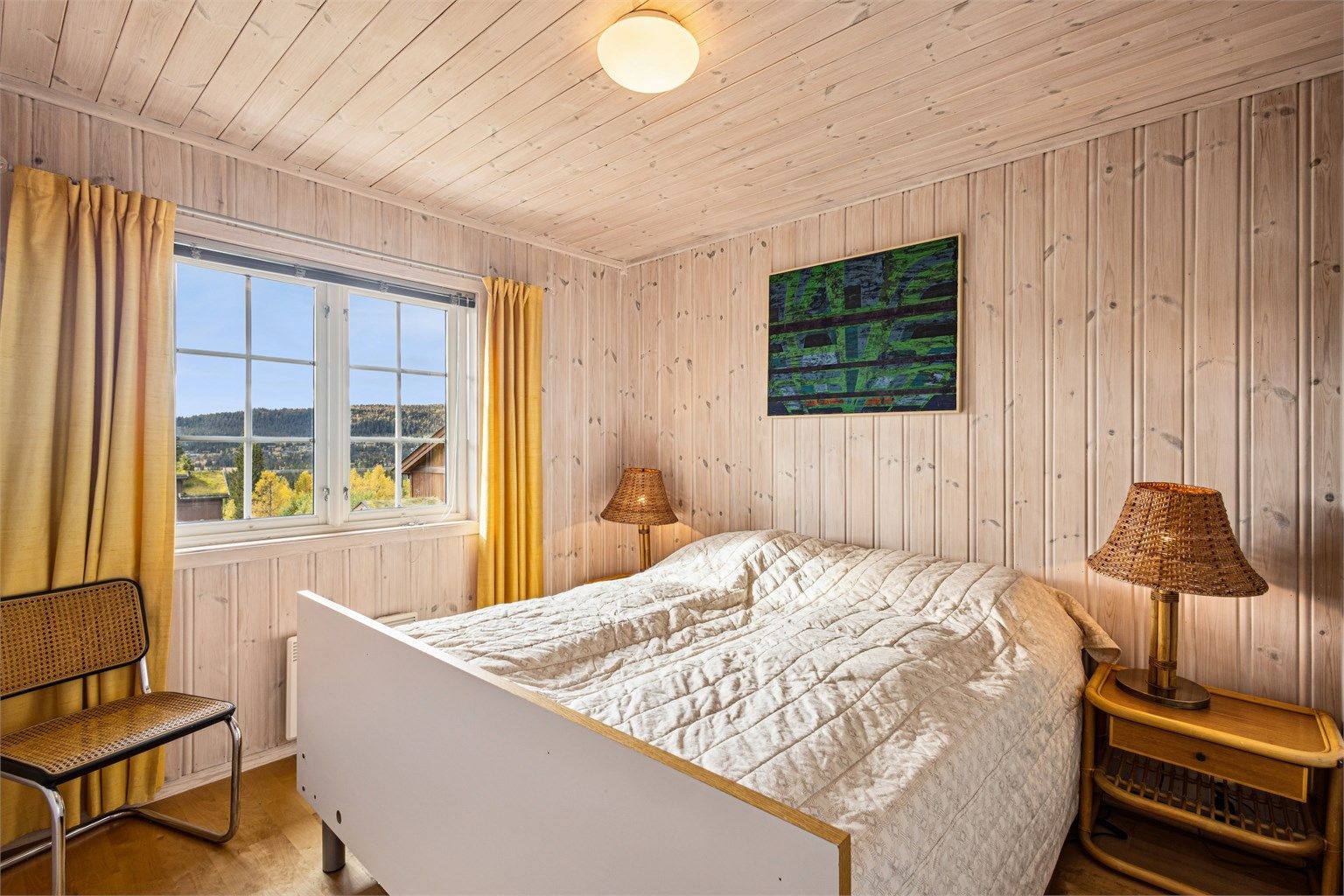 Hovedsoverommet er innredet med dobbeltseng og har utsikt mot fjellandskapet.