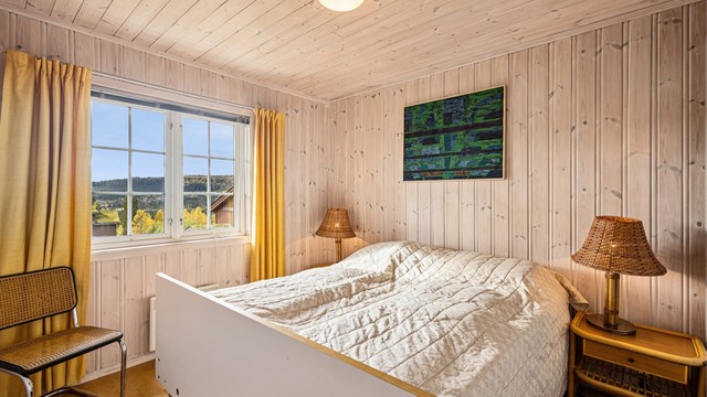 Hovedsoverommet er innredet med dobbeltseng og har utsikt mot fjellandskapet.