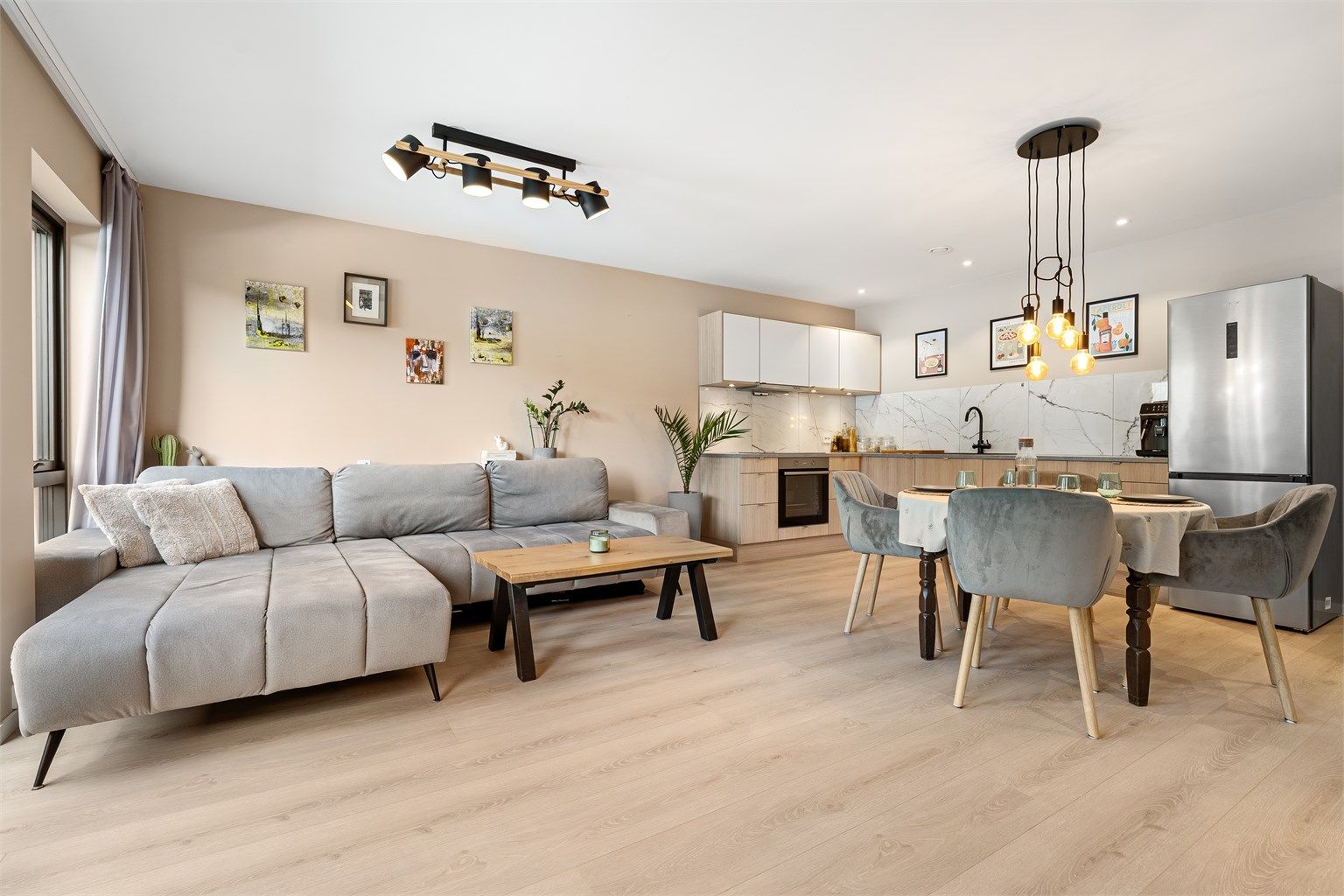 Romslig stue i åpen løsning mot kjøkken, som gir gode sosiale soner og en luftig romfølelse.