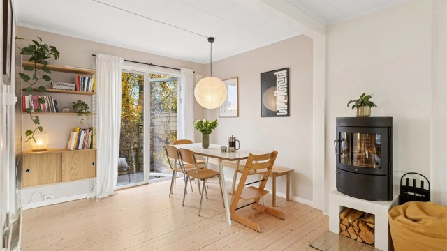 De originale tregulvene og den funksjonelle vedovnen gir spisestuen en varm og sjarmerende atmosfære.