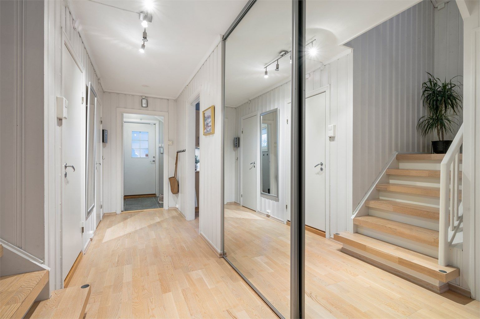 Videre kommer man til en praktisk gang med ytterligere oppbevaringsmuligheter. Praktisk plassbygd skyvedørsgarderobe. 