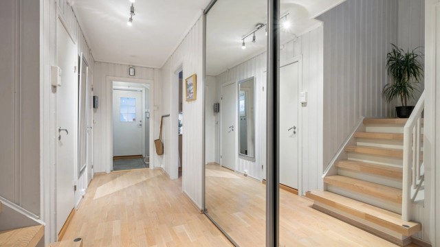 Videre kommer man til en praktisk gang med ytterligere oppbevaringsmuligheter. Praktisk plassbygd skyvedørsgarderobe.