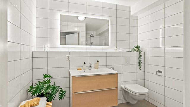 Badet i underetasjen er flislagt og har servantseksjon med skuffer og speil med integrert belysning.