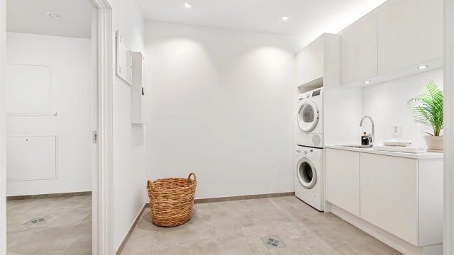 Vaskerom med romslig innredning fra HTH med hvite glatte fronter og god oppbevaringsplass. Benkeplate av laminat med nedfelt skyllekum med ett-greps armatur. Opplegg for vaskemaskin og tørketrommel.