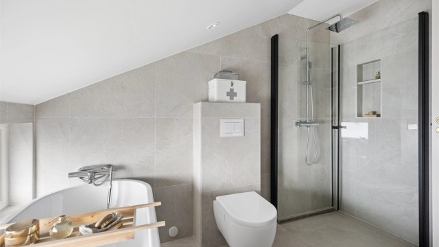 Lekkert, flislagt bad oppgradert i 2020. Badet fremstår som moderne og innbydende med badekar, dusjhjørne, servantinnredning og vegghengt toalett.