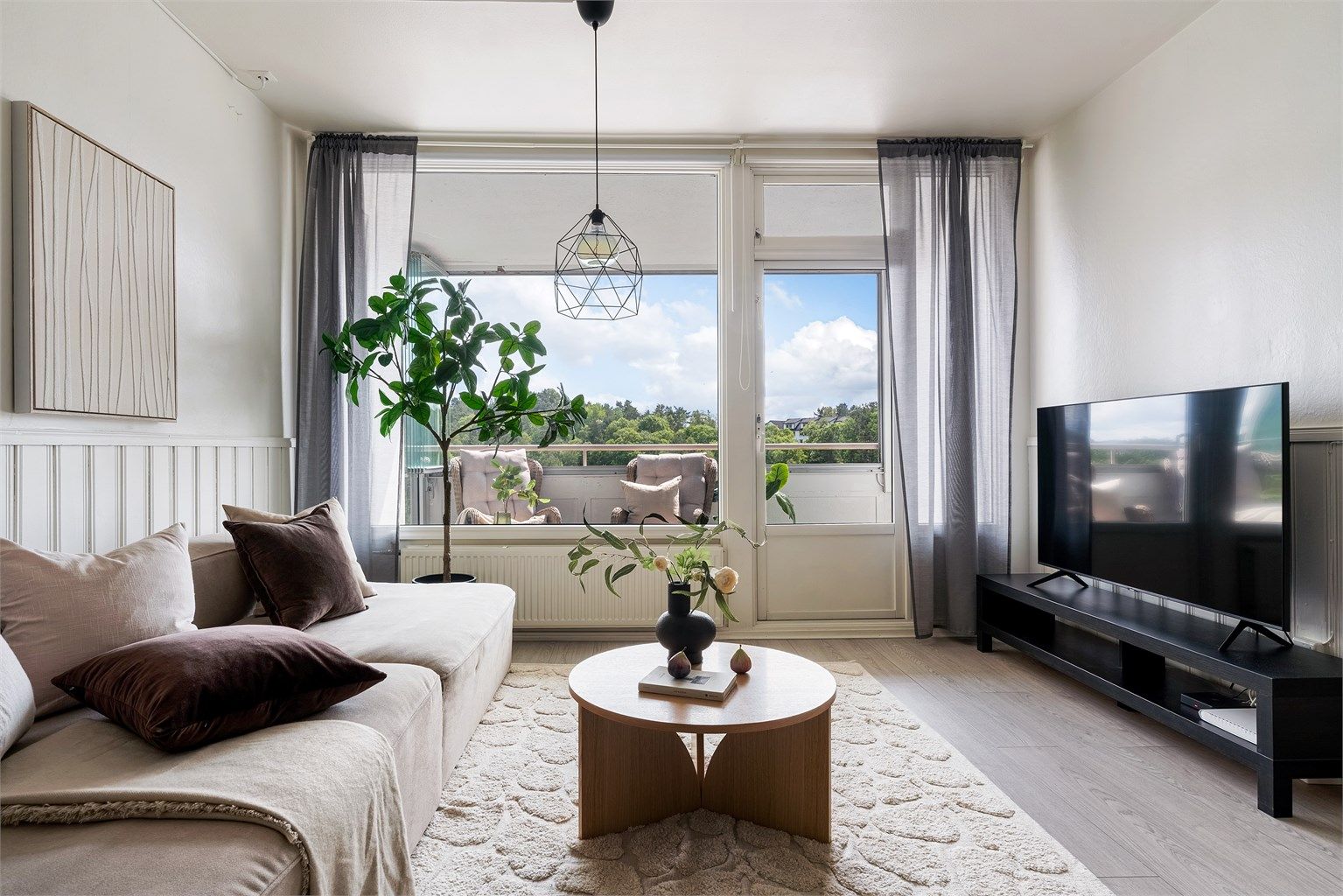 Flott lys stue med store vindusflater som slipper inn rikelig med dagslys