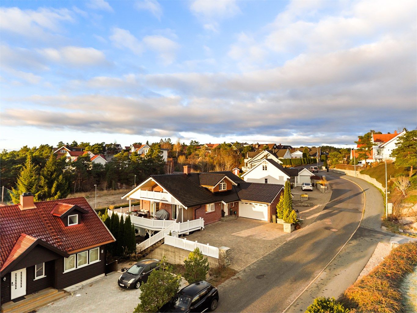 Utenom garasjen er det oppstillingsmuligheter for flere biler på den romslige gårdsplassen, utført helhetlig med belegningsstein. 