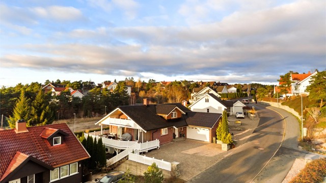Utenom garasjen er det oppstillingsmuligheter for flere biler på den romslige gårdsplassen, utført helhetlig med belegningsstein.