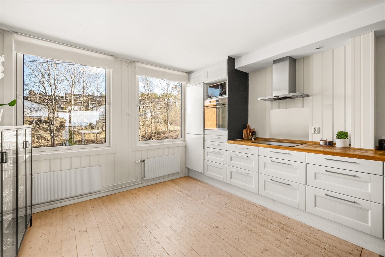 Hvitevarer som medfølger: integrert oppvaskmaskin, induksjonstopp, stekeovn og frittstående kjøleskap med frysedel.