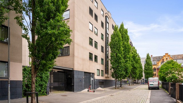 Jess Carlsens gate 6 har perfekt beliggenhet for den som ønsker å bo sentralt. Innkjøring til garasjeanlegg ved elsparkesykkelen. Boligen vender ut mot bakgården på andre siden.