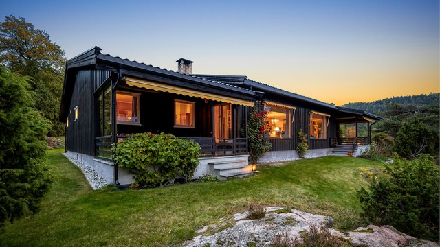 Fasaden i kveldslys med de overbygde terrassene mot hagen.