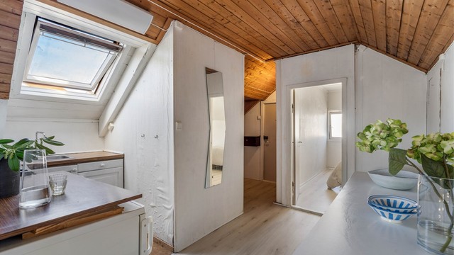 Loftet har en åpen løsning med takvindu og panel i taket.