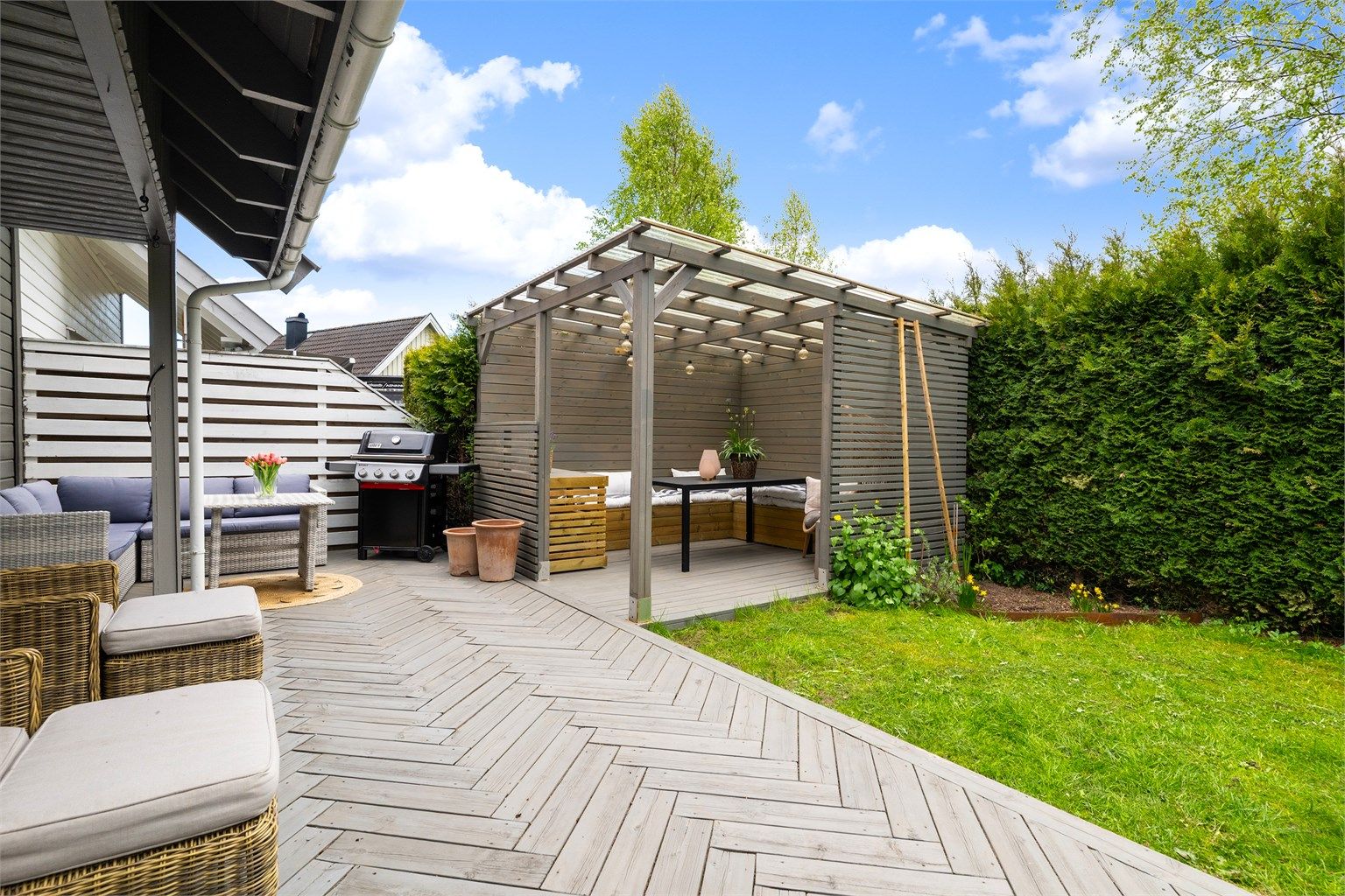 I forlengelsen av plattingen ligger en pergola med tett tak, bygget i 2021.