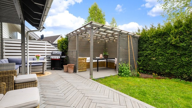 I forlengelsen av plattingen ligger en pergola med tett tak, bygget i 2021.