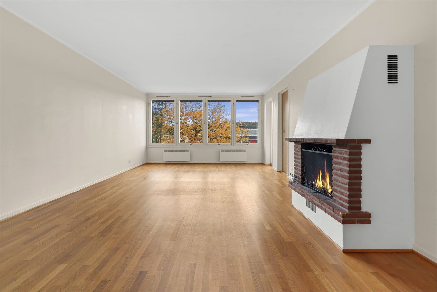 Leiligheten har en romslig stue med store vindusflater som gir naturlig lys inn i stuen. 