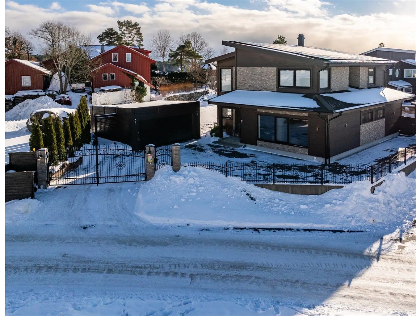 Inngjerdet tomt med en staselig, automatisk smijernsport som ønsker velkommen.