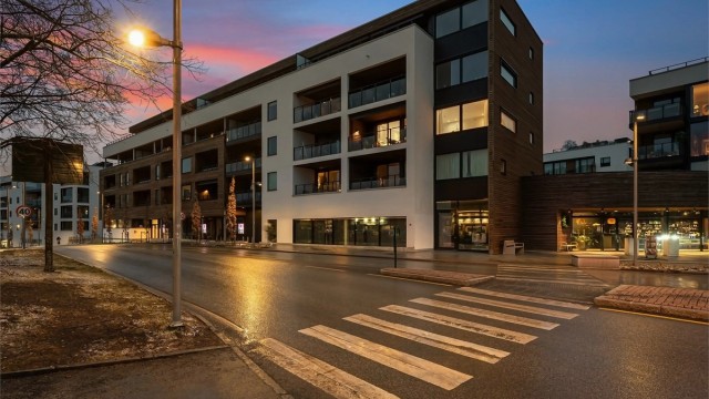 Bygget fra 2022 har en moderne fasade med en kombinasjon av trekledning og pussede fasadeplater.