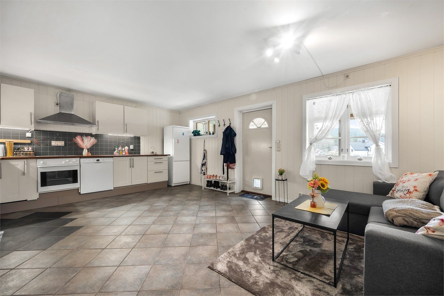 Utleiedelen har en åpen stue- og kjøkkenløsning fra 2010. Det er varmekabler i det flislagte gulvet.