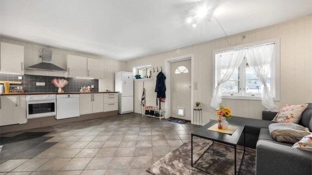 Utleiedelen har en åpen stue- og kjøkkenløsning fra 2010. Det er varmekabler i det flislagte gulvet.