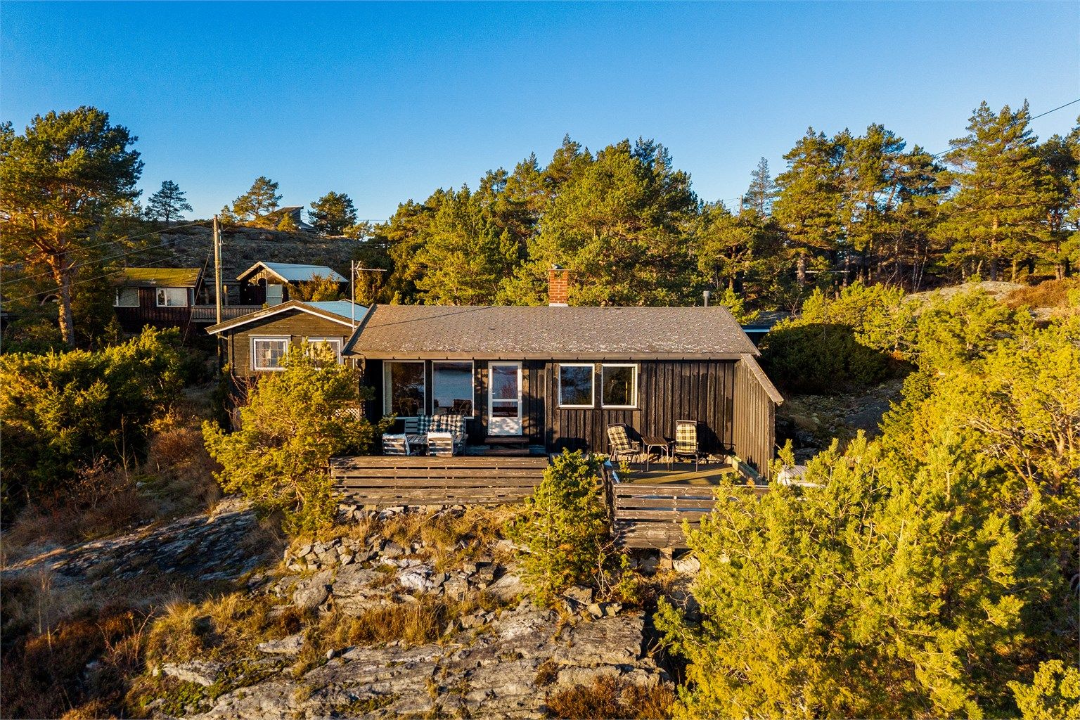 HYTTA ER SVART på utsiden og ligger lavt i landskapet.