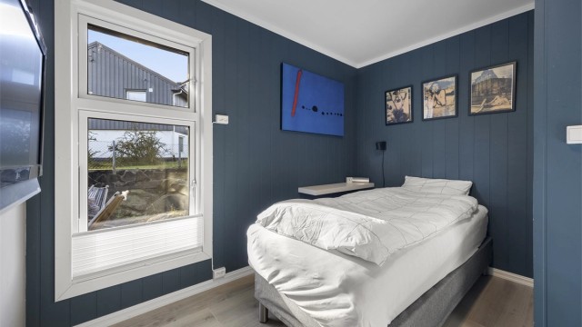 Det tredje soverommet er innredet med malt panel på veggene og laminat på gulv.