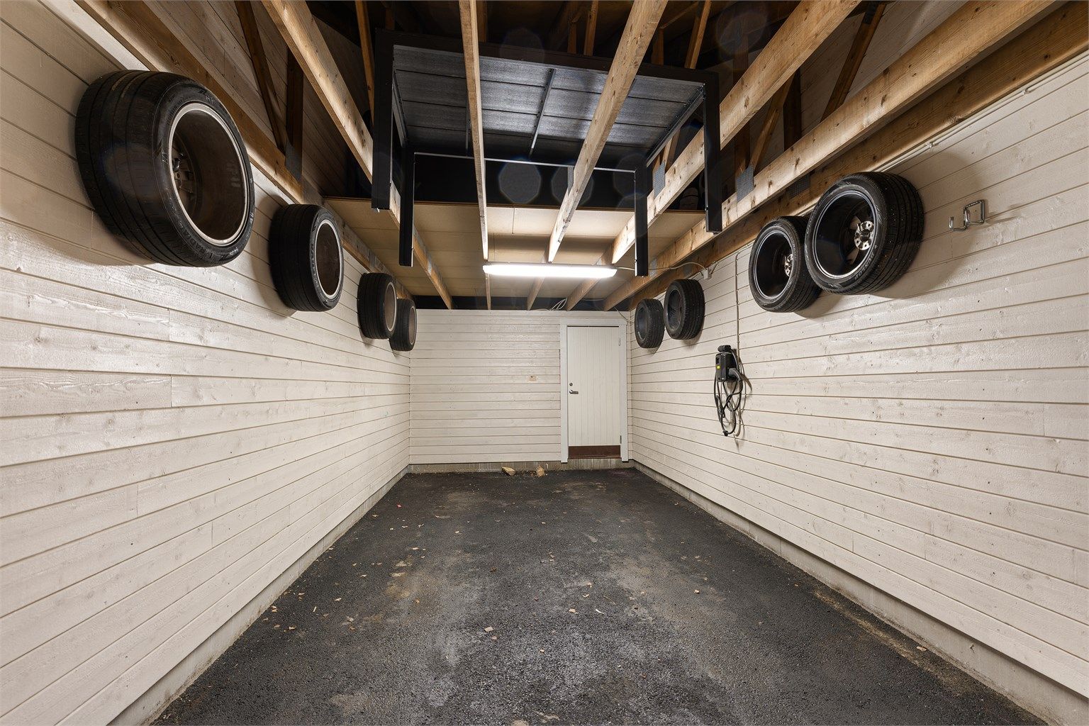 Carporten har nylig fått ny asfalt, og det er klargjort for installasjon av elbillader.