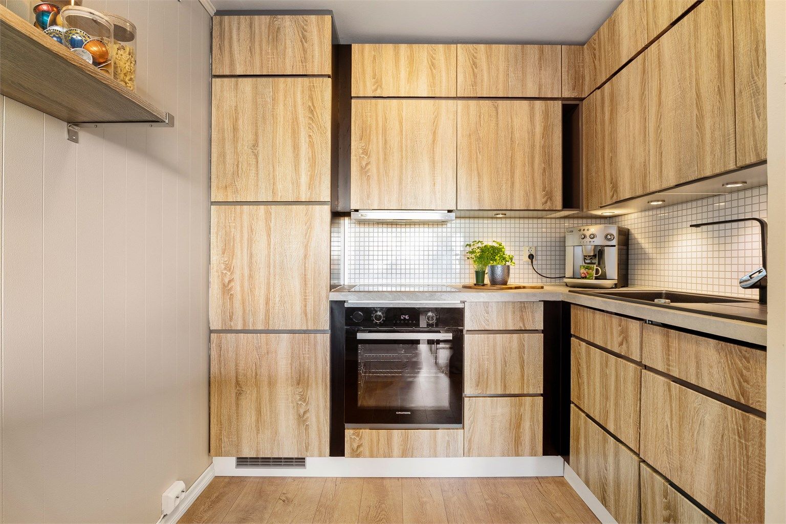 Kjøkkeninnredning fra Kvik (2010) med integrerte hvitevarer som kjøleskap, oppvaskemaskin (byttet 2024), stekeovn (byttet 2024) og platetopp. 