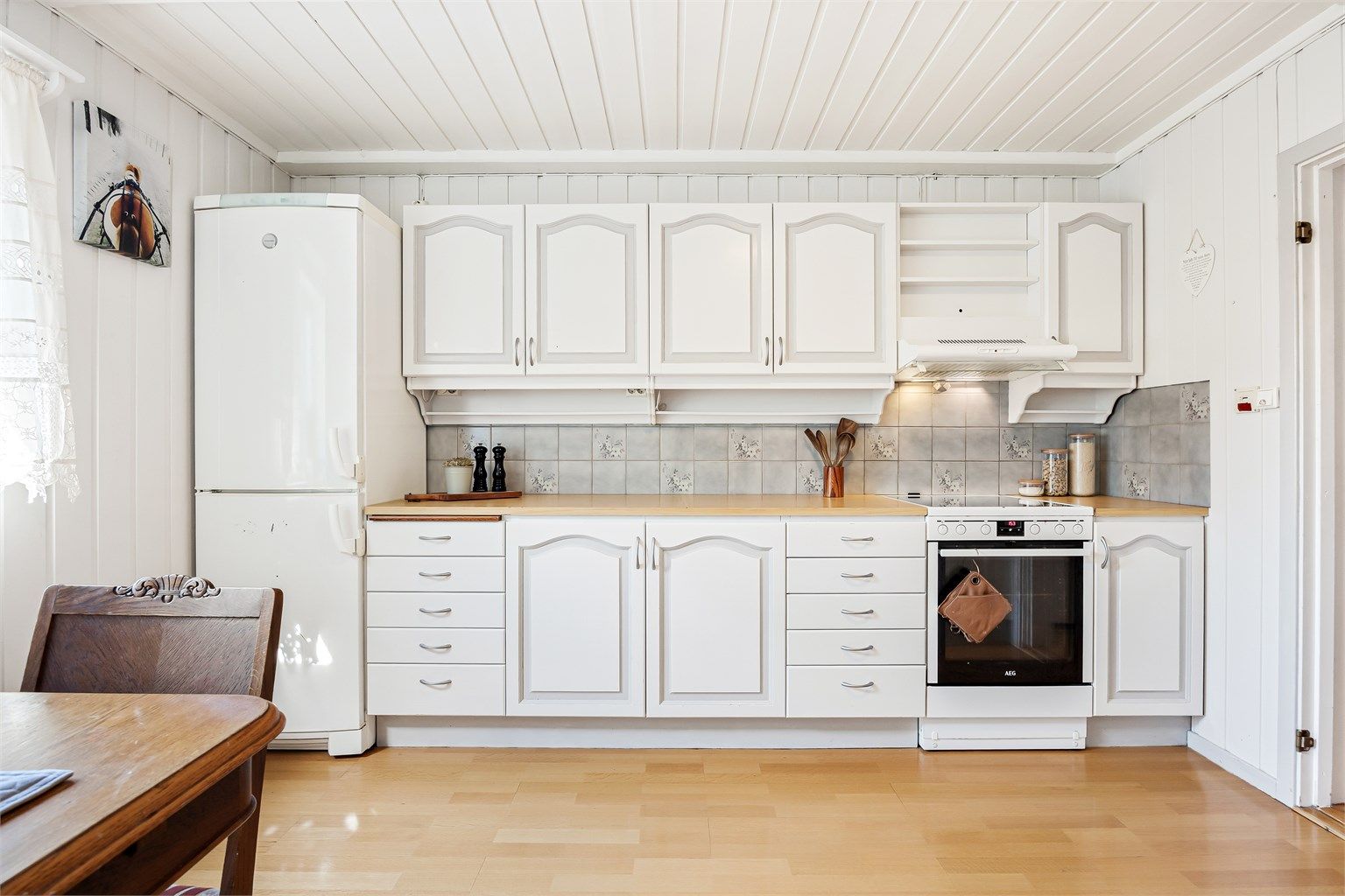 Kjøkkenet er utstyrt med laminert benkeplate, frittstående komfyr og ventilator.